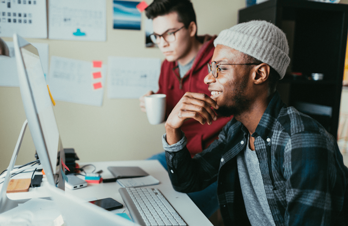 Two male QA engineers work at a desktop computer