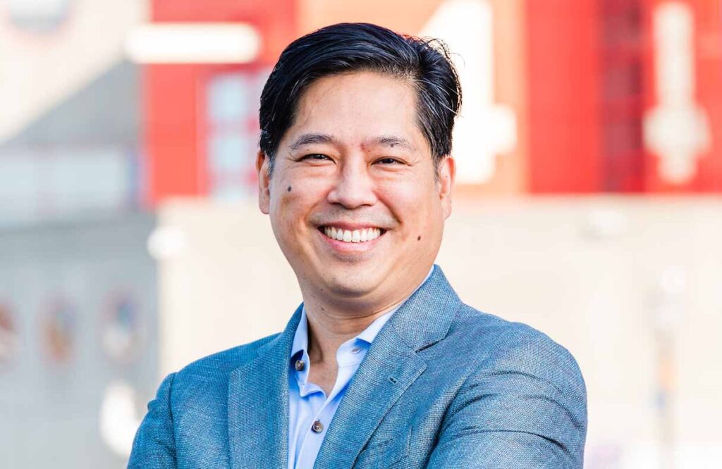 Catalyte's CEO Jacob Hsu's headshot set against the backdrop of Baltimore Inner Harbor