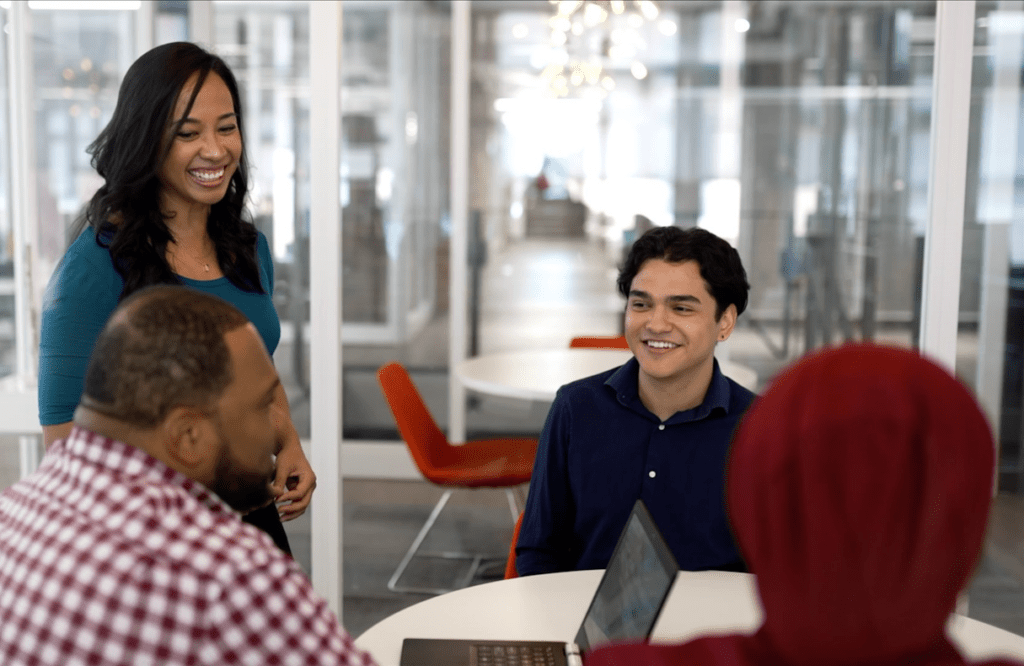 Four Catalyte apprentices discuss a client project around a conference table