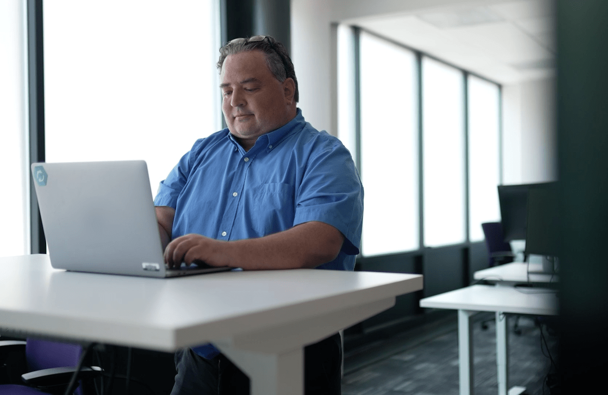 White male sits working at a laptop computer