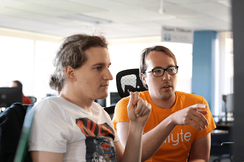 Two male Catalyte software developers look at a computer screen 