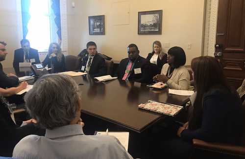 Group of 9 people discuss workforce development around a conference table