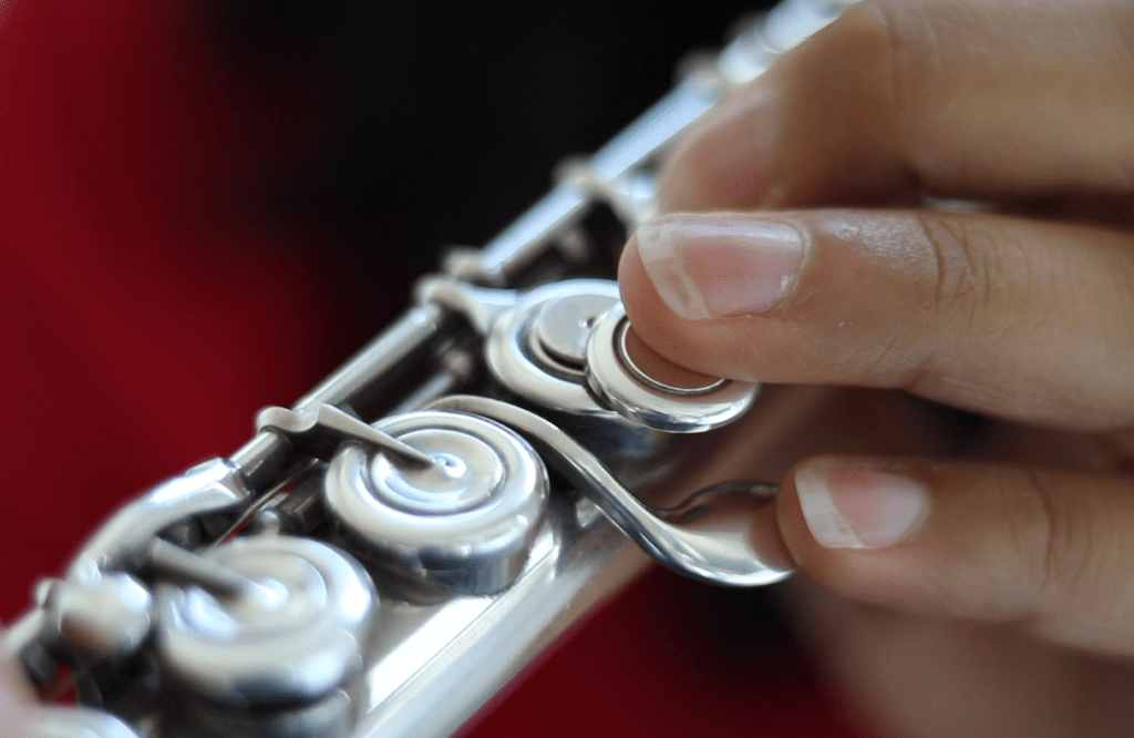 Close up of fingers playing a flute