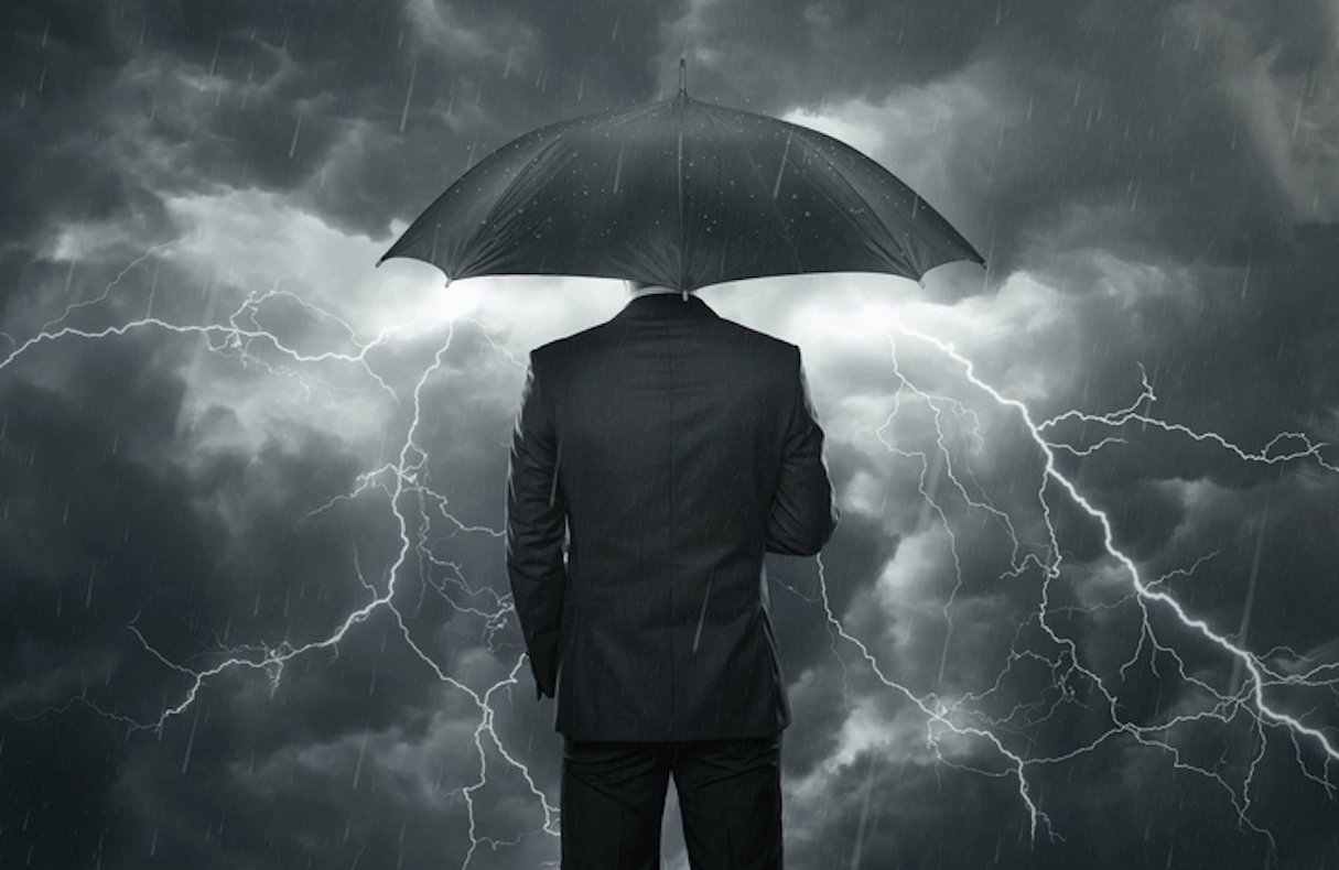 man standing under umbrella with lighting in the background