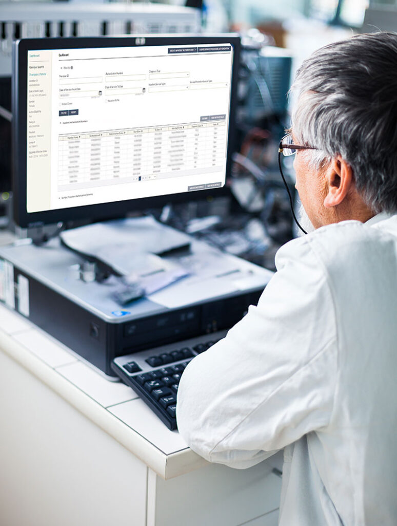 Medical professional reads information on computer screen