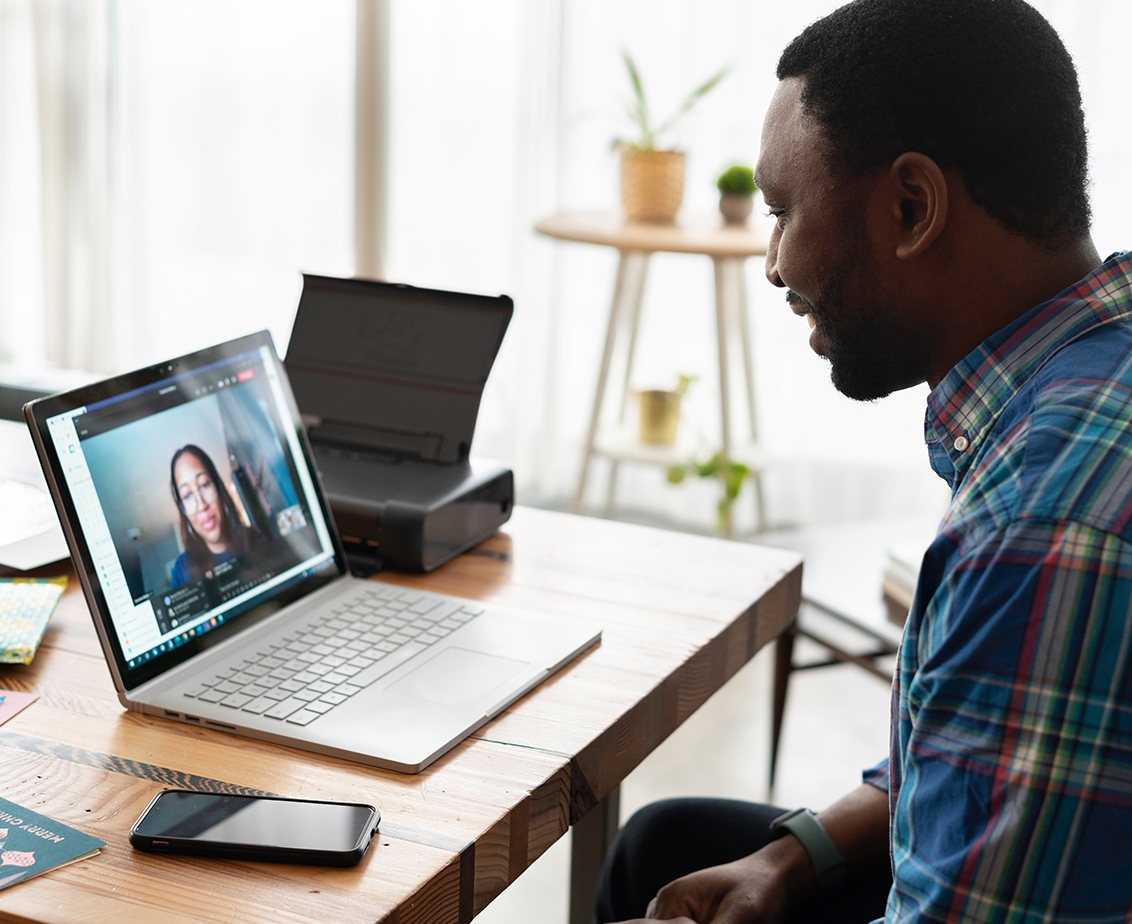 Man working from home office on video call with woman