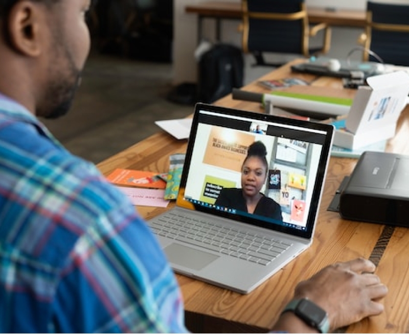 Man working from home office on video call with woman