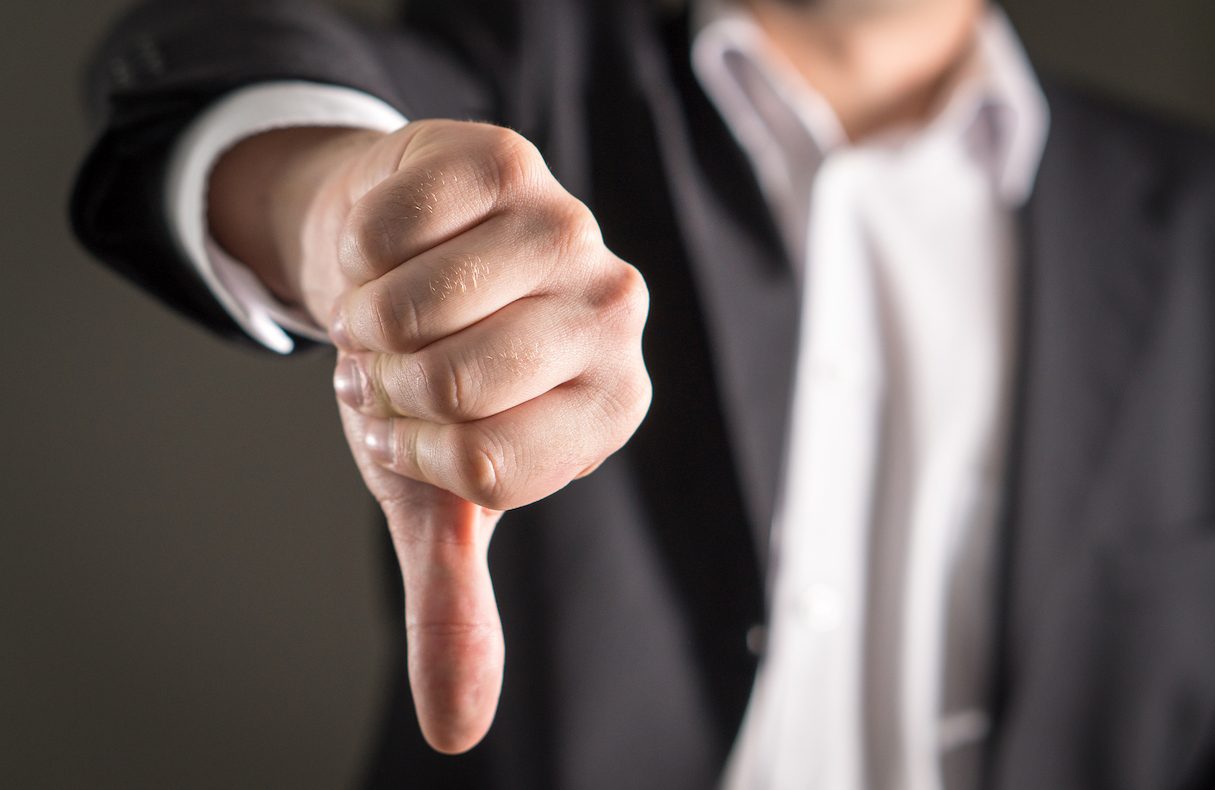 Businessman showing thumbs down.